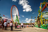 Seville, Spain, Apr 29 2009, Colorful rides spin in La Calle del Infierno at April's Fair, showcasing the lively atmosphere of Seville, Andalusia on a bright day.