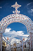 A street in Carrion de los Cespedes, Andalusia, Spain, is decorated with arches and colorful paper for the Virgen del Rosario procession.