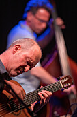 Seville, Spain, July 07 2022, Wolfgang Muthspiel performs on guitar with Larry Grenadier playing double bass in the background during a vibrant jazz concert in Sevilla.