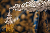 Close-up view of the detailed silversmithing on a handgrip of the paso of Virgen de la Merced during Holy Week in Seville, Spain.