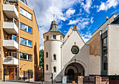 Oslo Synagogue features distinctive architecture alongside contemporary buildings on a clear day in Norway's capital city.