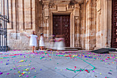 Kinder spielen nach einer farbenfrohen Hochzeitszeremonie fröhlich vor dem Eingang einer historischen Kirche.