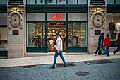 People walking by H&M flagship store in Chiado, Lisbon