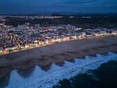Aerial view of Nazare beach and cityscape at night, Portugal