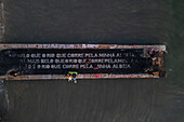 Aerial view of a poem by Alberto Caeiro, one of the heteronyms created by the Portuguese poet Fernando Pessoa, written on a dock of waterside Cais do Sodre, a buzzing nightlife and dining destination in Lisbon, Portugal