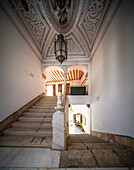 Barocke Treppe, die zu einer verzierten Decke in einem historischen spanischen Palast mit detailliertem Dekor führt.