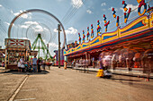 Seville, Spain, Apr 29 2009, Colorful rides whirl at La Calle del Infierno while visitors enjoy the lively atmosphere during daylight at April's Fair in Seville.