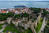 Aerial view of Sao Jorge Castle (Saint George's Castle), city skyline and cruise boat in Lisbon, Portugal