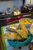 A vibrant Christmas table display features a variety of breads and festive dishes, creating a warm and inviting atmosphere.