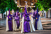 Participants of the Cigarreras brotherhood carry the Cruz de Guia during a solemn procession in Seville's streets during Holy Week.