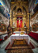 Seville, Spain, May 15 2022, Ornate chapel interior showcasing golden baroque altar and religious sculptures in Seville's church.