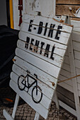 Holzschild eines E-Bike-Verleihs in Nazare