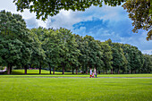 Oslo, Norway, Aug 10 2017, Two individuals walk hand in hand on a lush green path surrounded by trees in Frogner Park, Oslo, enjoying a beautiful day.