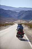 Two cycle tourists on a lonely road in the area of Death Valley, California