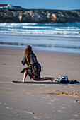 Young woman training strength and mobility on the beach of Baleal Island