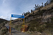 Entrance sign for the Los Nevados Natural National Park in Colombia, with frailejones plants on the hilltop.