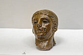 A small statuette of a female head in the Vesuvian Life Gallery, National Archaeological Museum of Naples, Naples, Italy. The lead-glazed terra sculpture is from Pompeii, circa 1st Century A.D.
