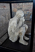 Plaster cast of a victim of the volcanic eruption, displayed in the Macellum in the ancient Roman ruins of Pompeii in Italy.