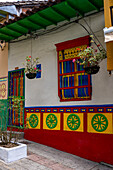Bunt bemalte Holzarbeiten und ein 3-D-Wandbild aus Gips oder Zócalo an einer Hauswand in Guatape, Kolumbien.