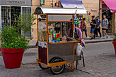 A vendor selling food snacks & toys from her mobile cart on a pedestrian street in Salta, Argentina.