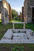 An impluvium in the atrium of Casa della Statuetta Indiana or House of the Indian Statuette, Building I.8.5. Ruins of Pompeii, Italy.