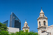 Complejo Juan Felipe Ibarra or Juan Felipe Ibarra Complex, a modern office building in Santiago del Estero, Argentina. In front is the cathedral bell tower.