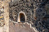 A niche in a wall of the House of the Sailor, Building VII.15.2, in the ancient Roman ruins of Pompeii in Italy.
