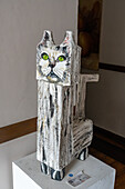 A painted wooden sculpture of a cat by artist Beatriz Gomez in a hotel in Medellin, Colombia.