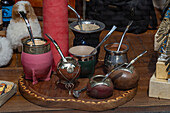 Yerba mate gourd cups and bombilla straws in the window display of a souvenir shop in Salta, Argentina.