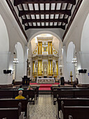 Worshippers in the nave of the Basilica of Our Lady of Candelaria, Medellin, Colombia.