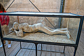 Plaster cast of a victim of the volcanic eruption, displayed in the Macellum in the ancient Roman ruins of Pompeii in Italy.