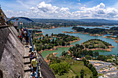 Tourists at the top of the Piedra del Penon or Penon de Guatape, near Guatape, Colombia, overlooking the Embalse del Penol.