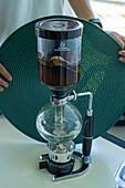 Eine Siphon-Kaffeemaschine brüht Kaffee während einer Besichtigung einer Kaffeefarm in Kolumbien.