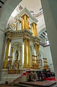 Large gold candlesticks in front of the main altarpiece in the Basilica of Our Lady of Candelaria, Medellin, Colombia.