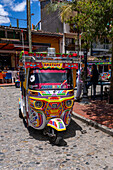 Ein farbenfrohes Motochiva oder Mototaxi, ein Touristenverkehrsmittel in der Stadt Guatape, Kolumbien.