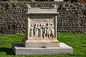 The marble altar of Temple of the Genius of Augustus, Building VII.9.2, in the ancient Roman ruins of Pompeii, Italy. The bas relief on the front of the altar depicts the sacrifice of a bull.