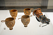 Terra cotta drinking vessels in the National Archaeological Museum of Naples, Naples, Italy. Magna Graecia Collection. #23 - skyphoi or cups with handles, #21 - rhyton or drinking cup in the shape of a horse head.