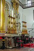 Large gold candlesticks in front of the main altarpiece in the Basilica of Our Lady of Candelaria, Medellin, Colombia.