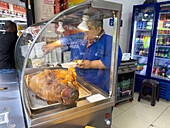 A fast food booth on the street selling meat from a roasted pig in Medellin, Colombia.