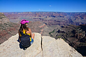 Sitting young woman enjoying the views of Grand Canyon, Arizona