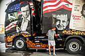 In Marchena, Seville, a man admires a uniquely designed trailer truck adorned with Johnny Cash artwork and American icons.