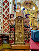 Two carved wooden female angels guard the pulpit in the nave of the Basilica of Our Lady of Mercy, Quito, Ecuador.