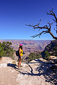 Standing young woman enjoying the views of Grand Canyon, Arizona