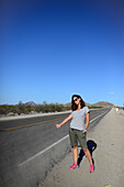 Young Caucasian woman hitchhiking on Route 66