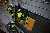Höhenansicht eines Höhenarbeiters beim Einbau eines Gebäudefensters