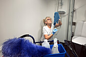Reife Hausmeisterin putzt Badezimmer