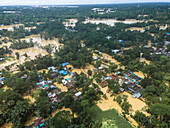 Aerial view of flooded highway and submerged village with waterlogged homes and stranded vehicles, Chittagong, Bangladesh.