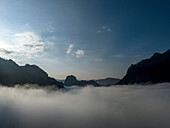 Luftaufnahme von majestätischen, in Nebel und Wolken gehüllten Bergen bei Sonnenaufgang, Bezirk Ngoy, Luang Prabang, Laos.