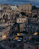 Aerial view of the historic medieval town of Matera with ancient stone buildings illuminated by night lights, Matera, Italy.