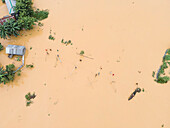 Aerial view of a flooded village with houses and boats surrounded by greenery, Jhenaigati, Sherpur, Bangladesh.